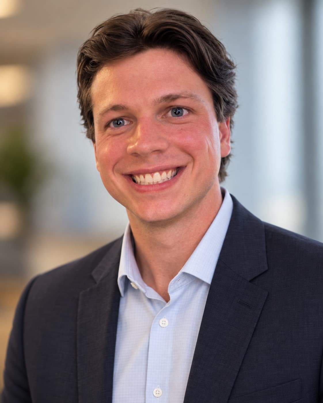 Brendan Reynolds, Rochester NY photographer, smiling in a navy blazer